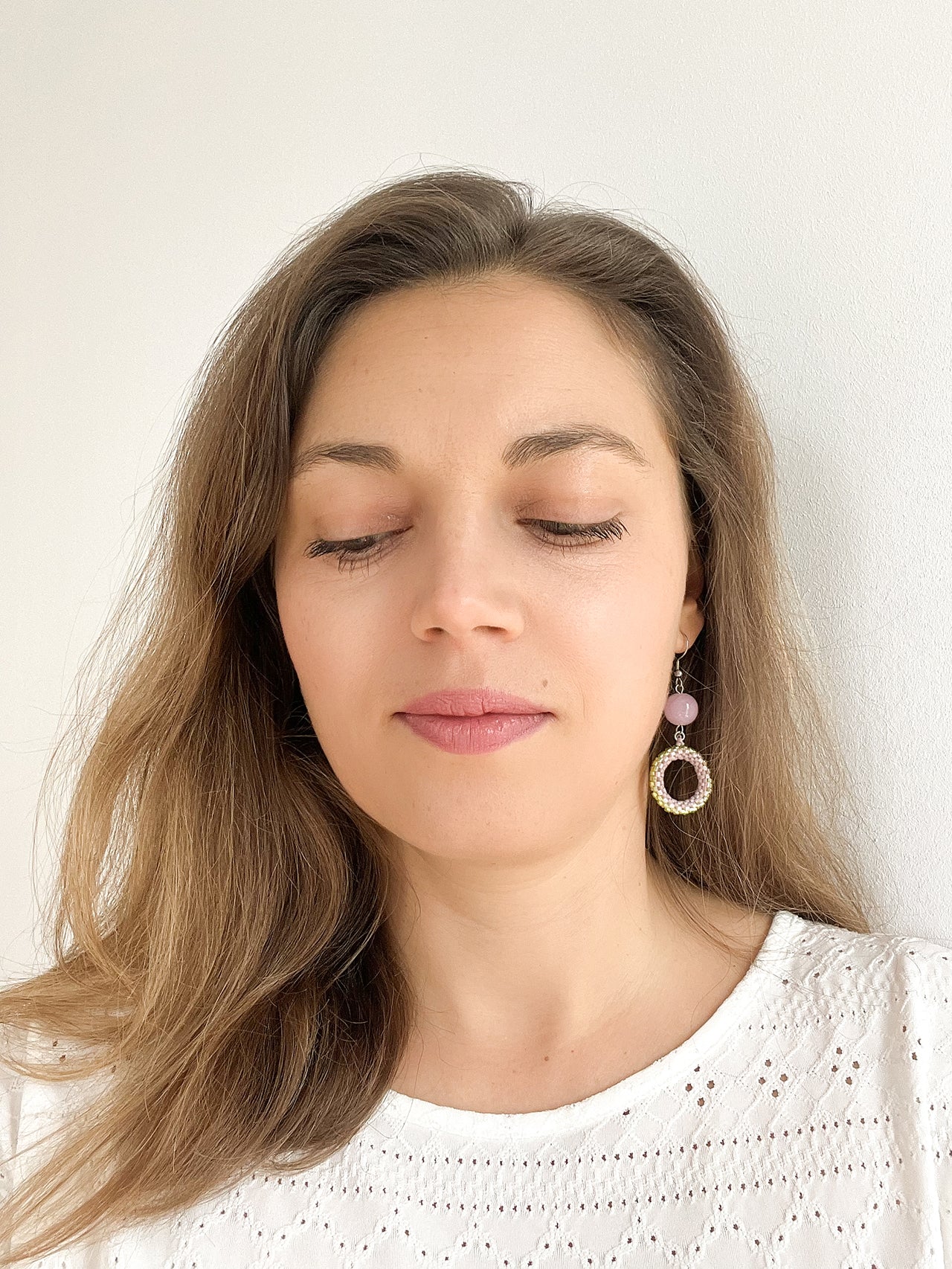 femeie cu bluza alba si cercei cu cercuri pastel