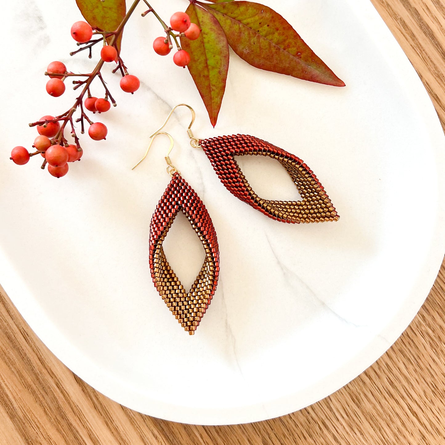 Cercei panglica rasucita din margele metalizate rosu ruginiu si auriu